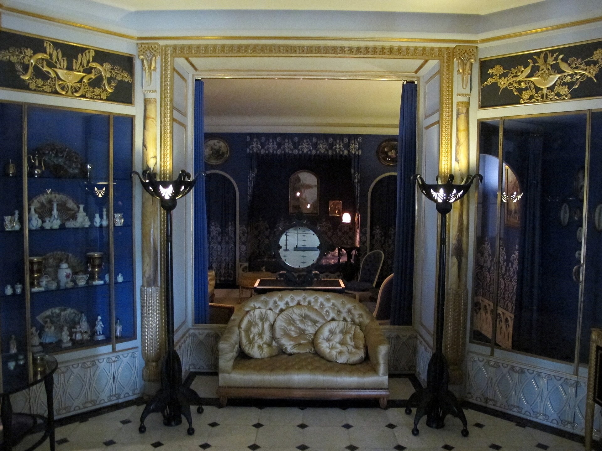 Blue display cases, gilded wall friezes and an upholstered alcove furnish Jeanne Lanvin’s historic boudoir.