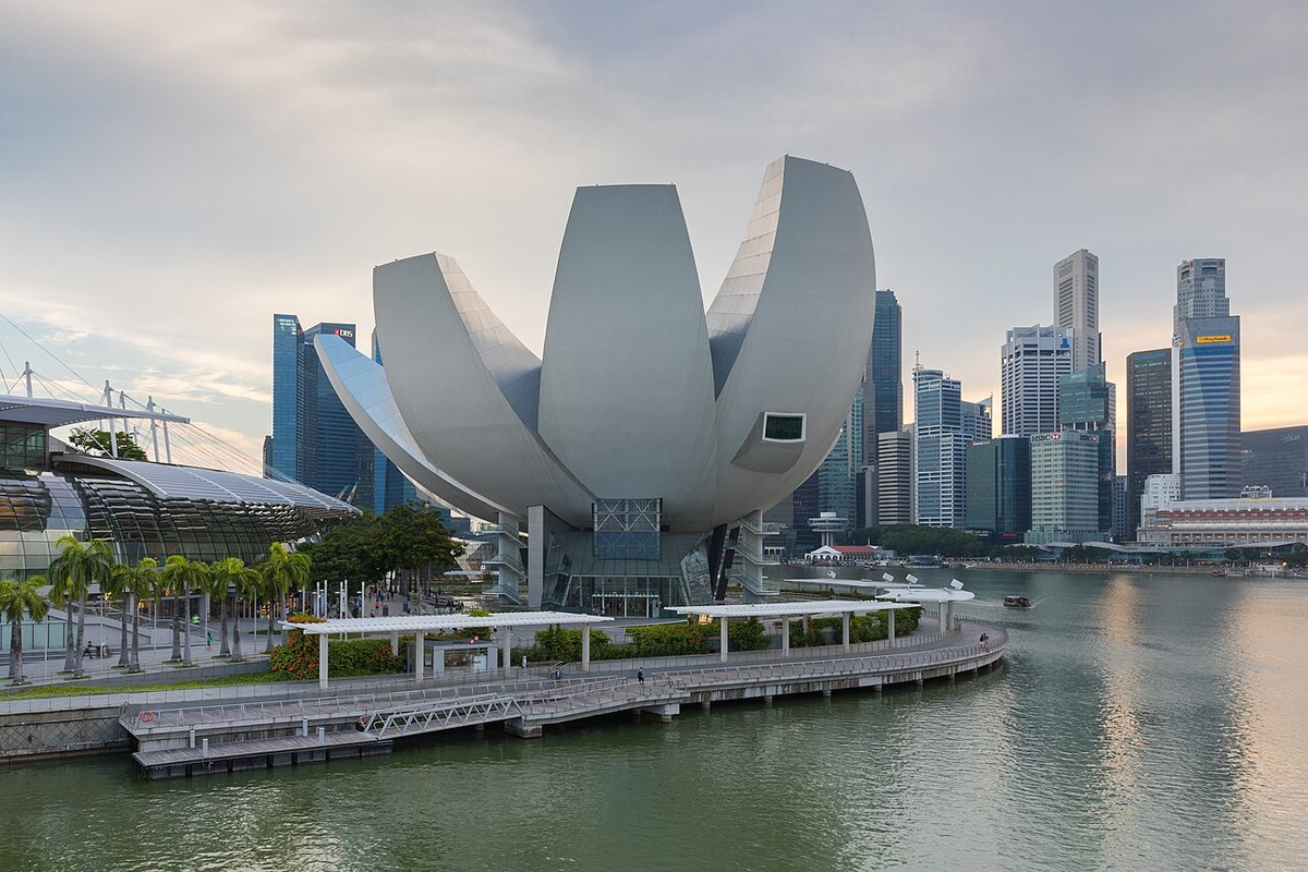 White lotus-shaped ArtScience Museum beside Marina Bay, with city towers across the water.