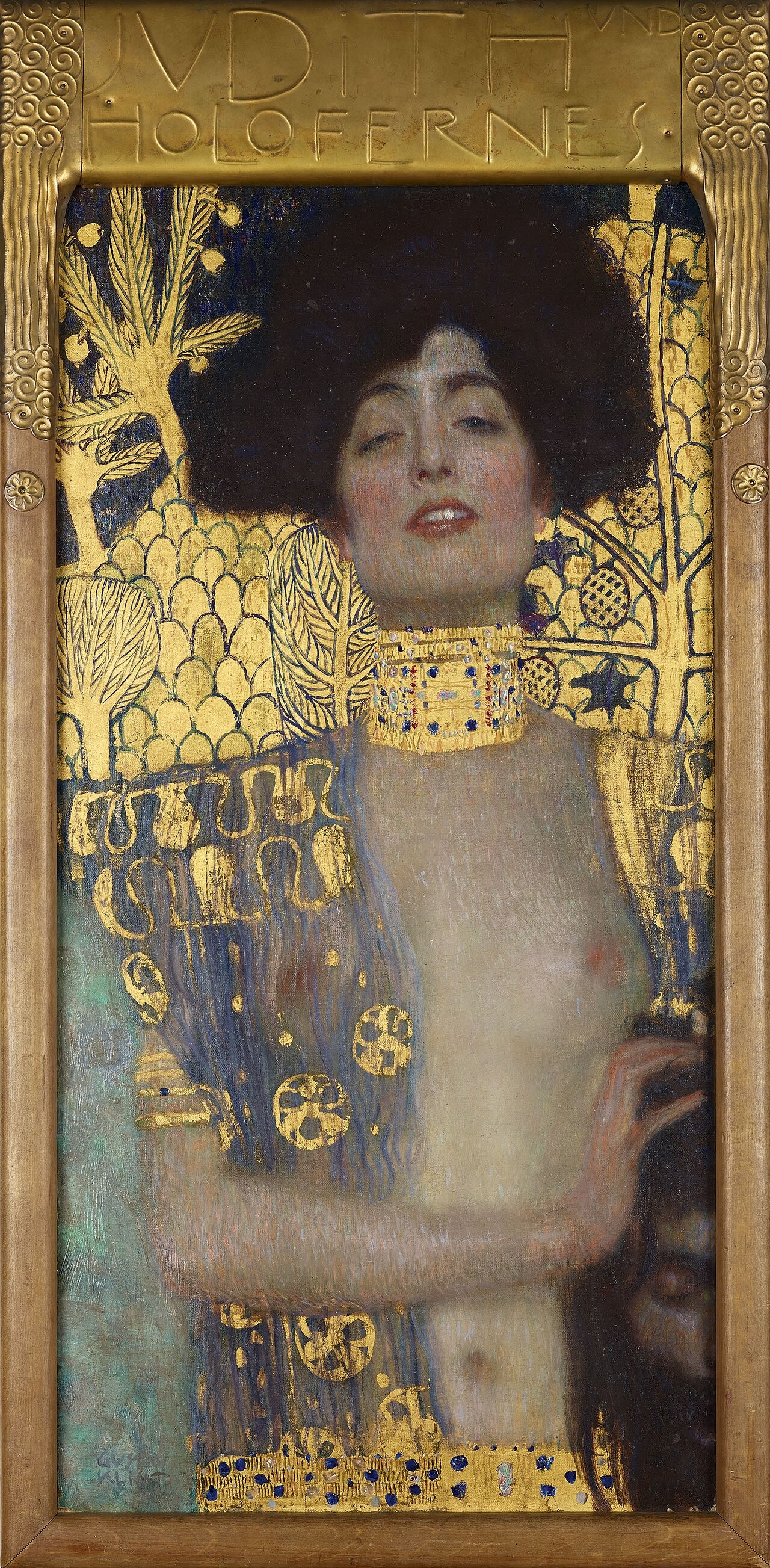 A woman in a gold collar rests a hand on a dark-haired severed head, surrounded by gold pattern.