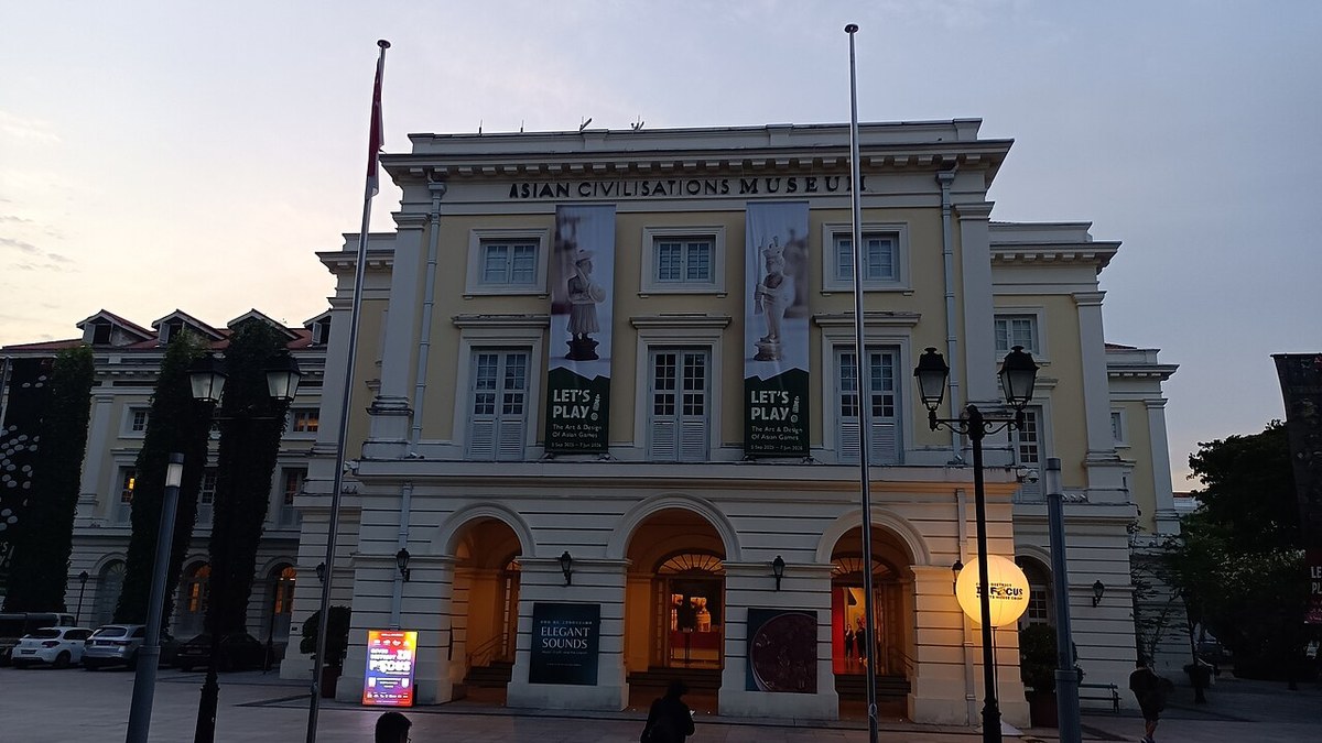 Front entrance of the Asian Civilisations Museum at dusk, with illuminated ground-floor arches.