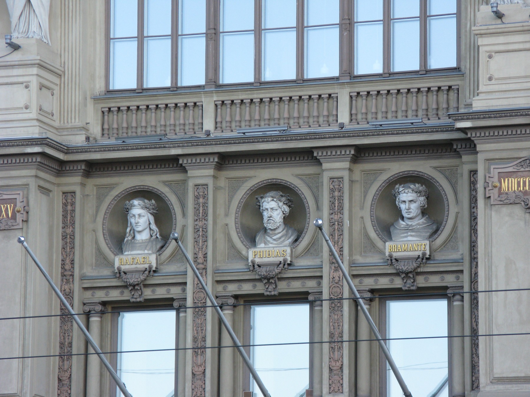 Three sculpted busts in circular niches on the Ateneum façade.