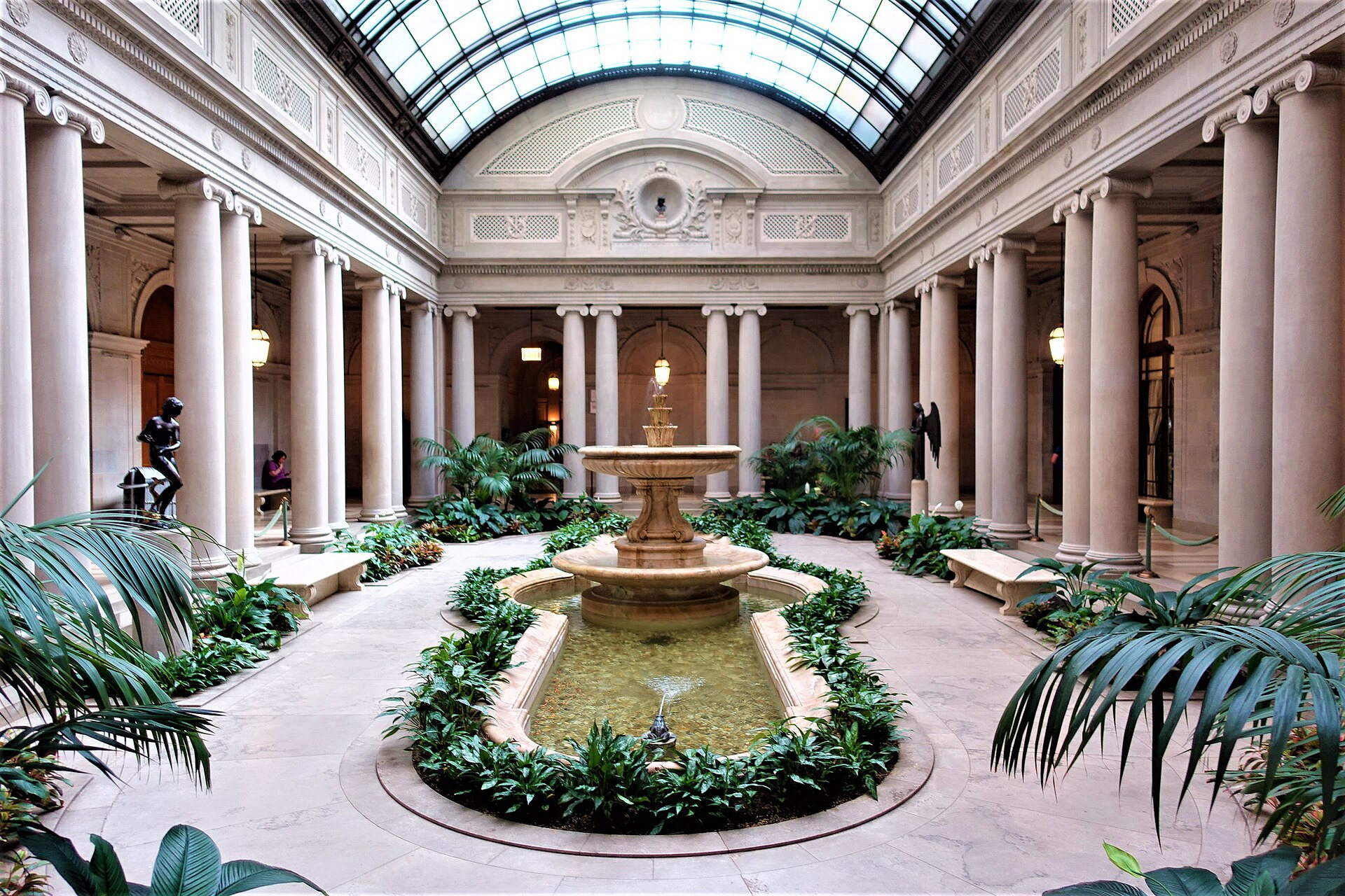 Fountain and paired columns beneath the glazed ceiling of the Frick Garden Court