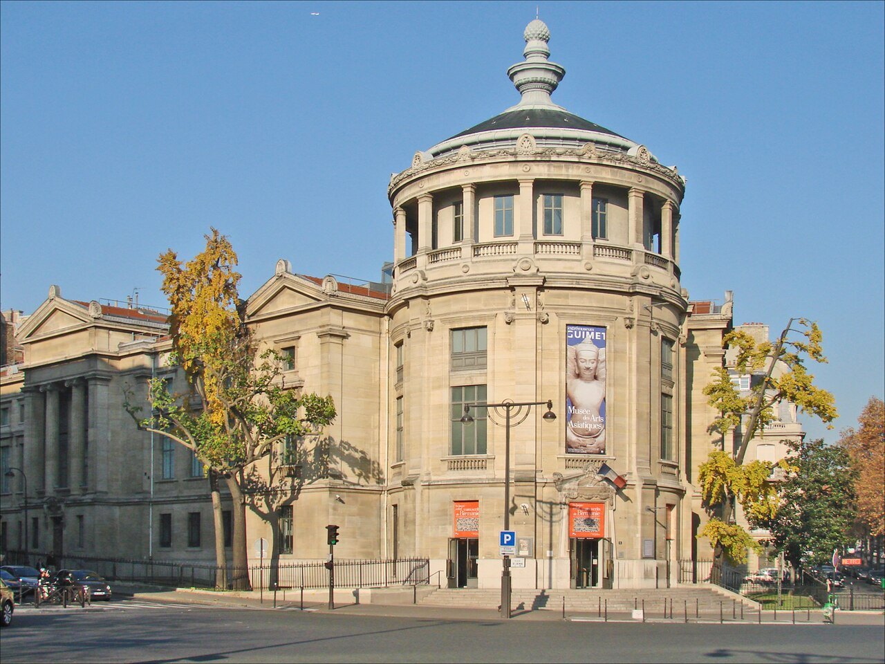 The rounded stone entrance tower of the Musée Guimet beneath a clear blue sky.