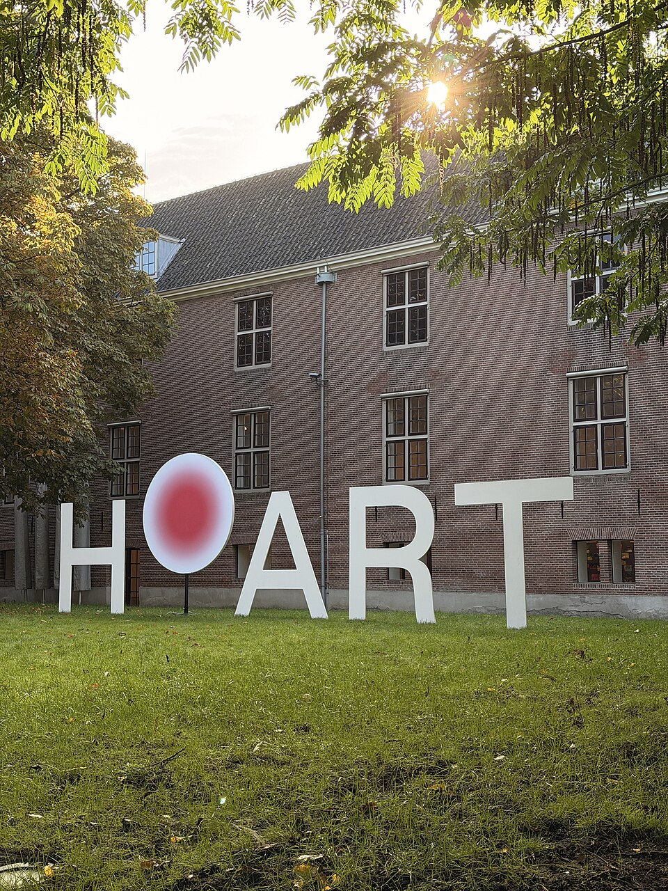White H’ART letters on a lawn in the Amstelhof courtyard