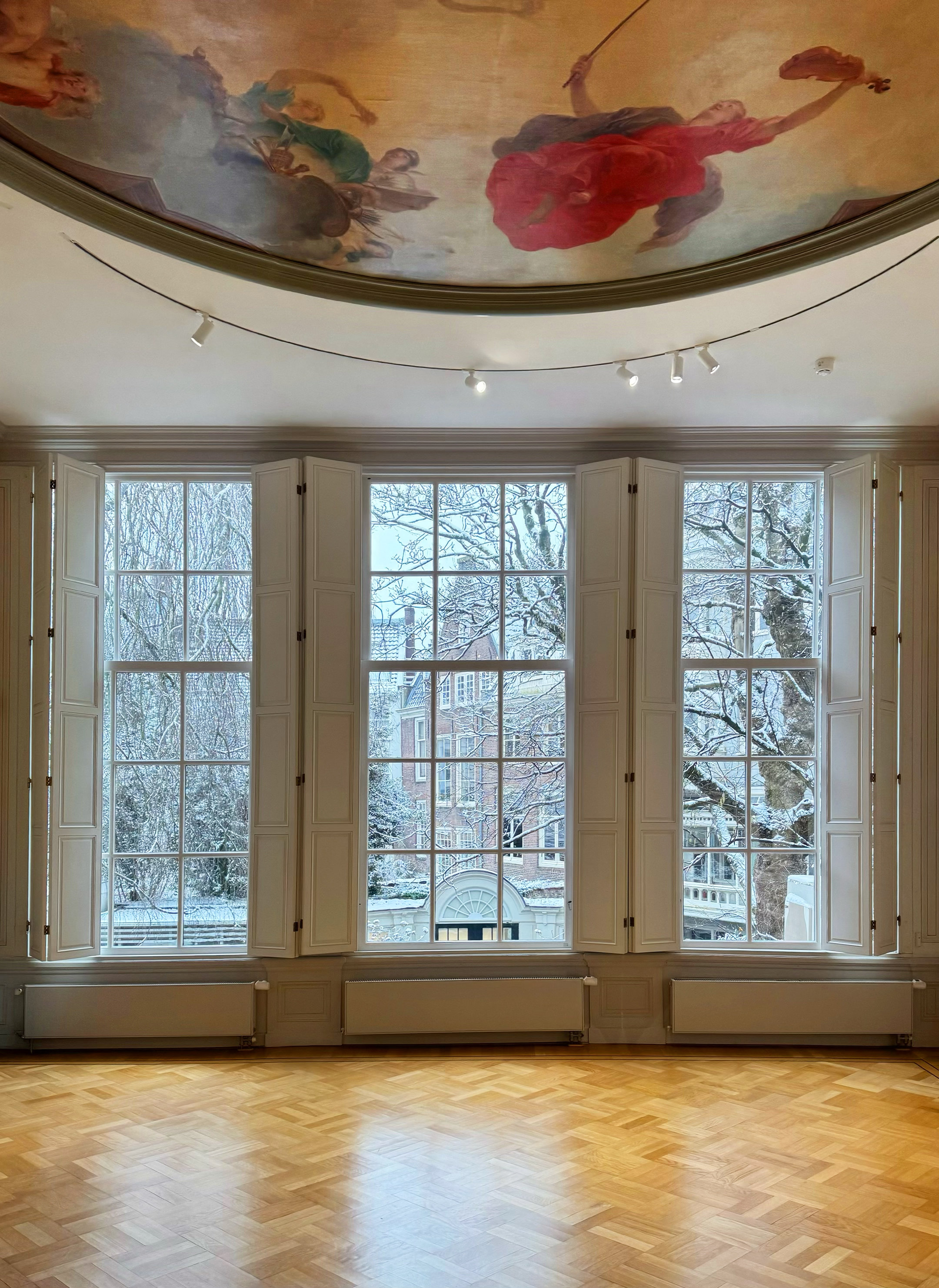 Windows and Jacob de Wit ceiling painting in the historic Garden Room at Huis Marseille