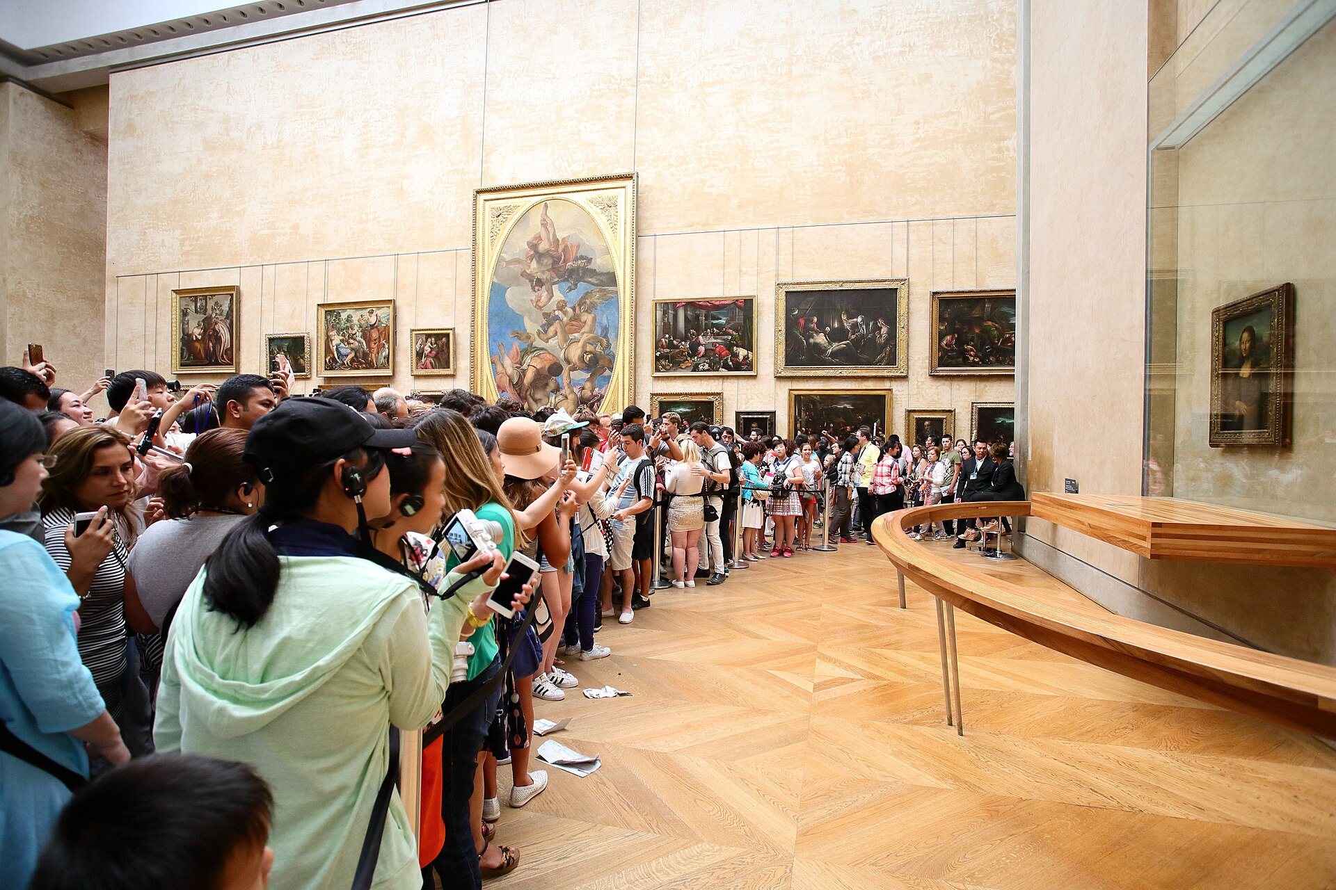 Visitors crowding in front of the Mona Lisa in the Louvre's Salle des États.