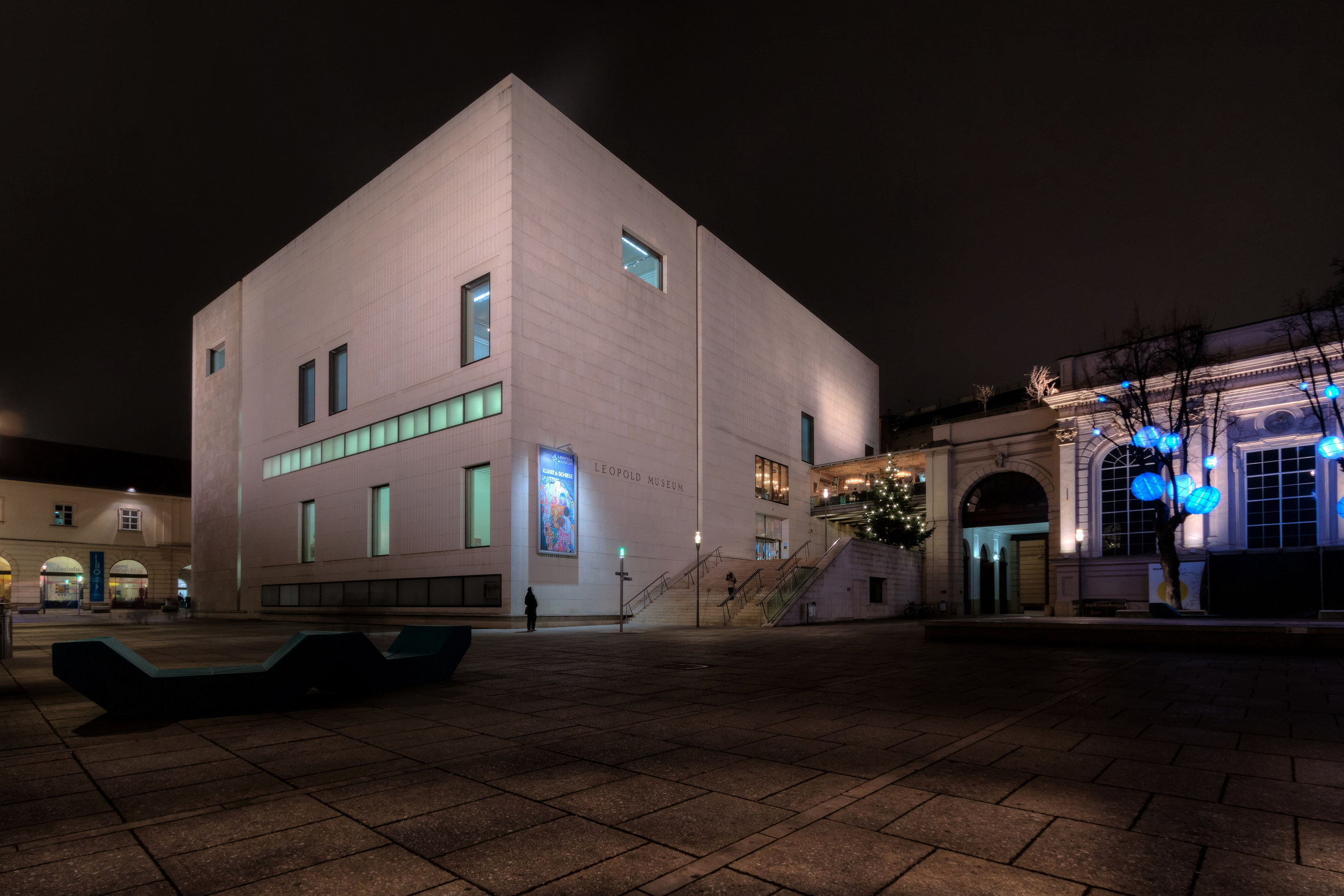 The pale stone Leopold Museum lit at night in the MuseumsQuartier