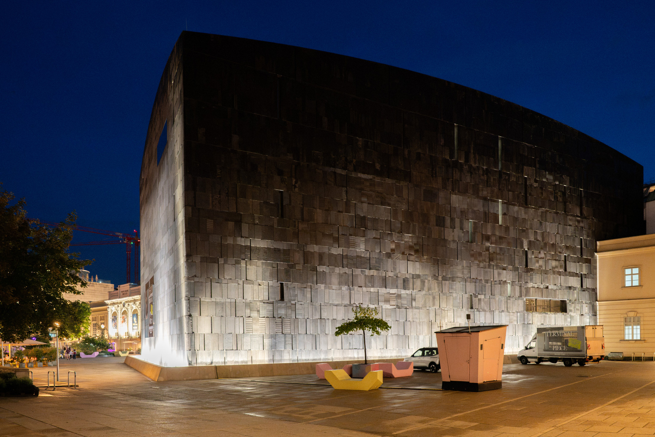 mumok's dark basalt exterior lit at night in Vienna's MuseumsQuartier