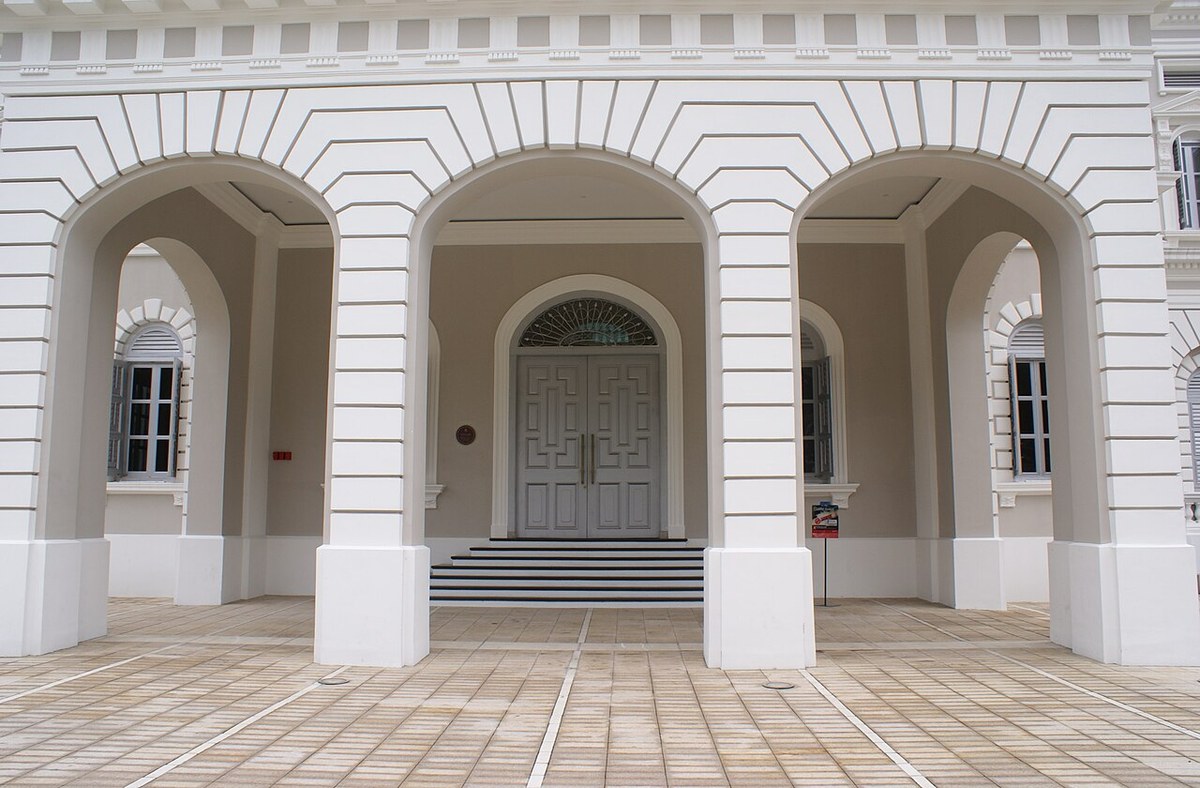 White arched porte-cochère framing the National Museum of Singapore’s front door.