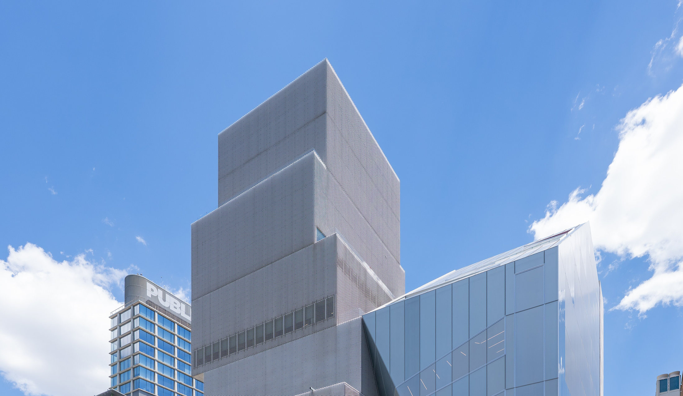 Upper façades of the New Museum’s SANAA building and its adjacent 2026 expansion
