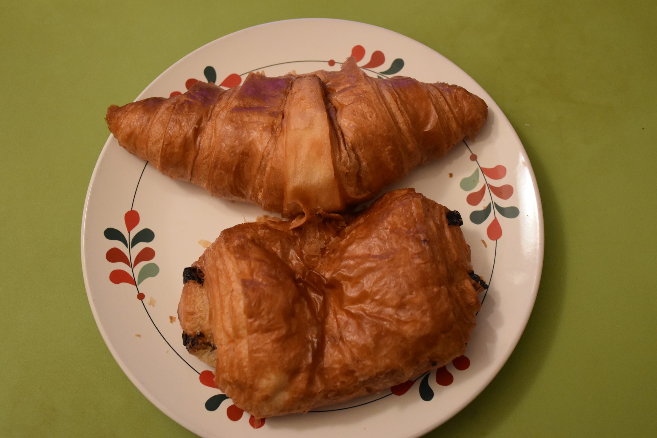 A croissant and a pain au chocolat on a patterned plate in Paris
