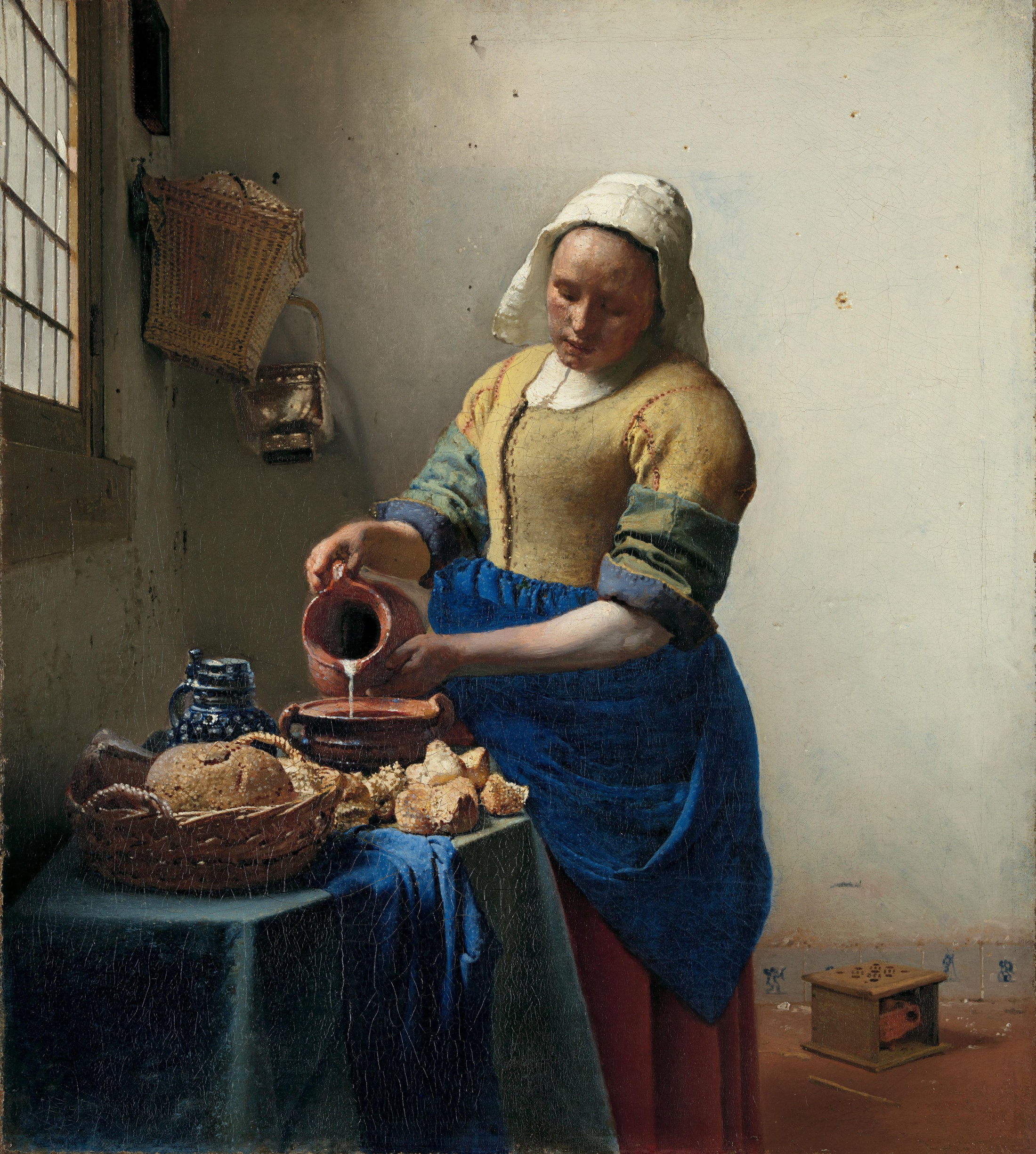 Johannes Vermeer’s The Milkmaid, showing a woman pouring milk beside a window