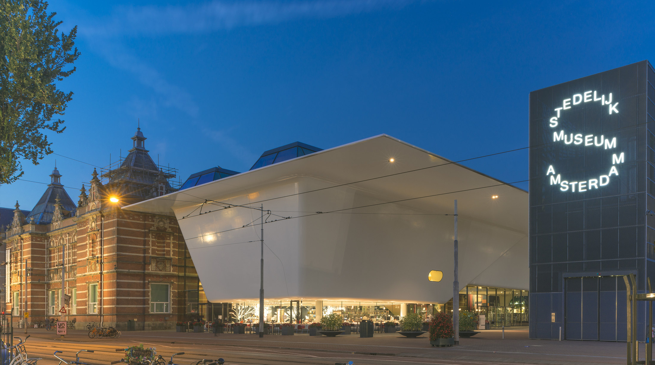 Stedelijk Museum’s white new wing and freestanding museum sign at dusk