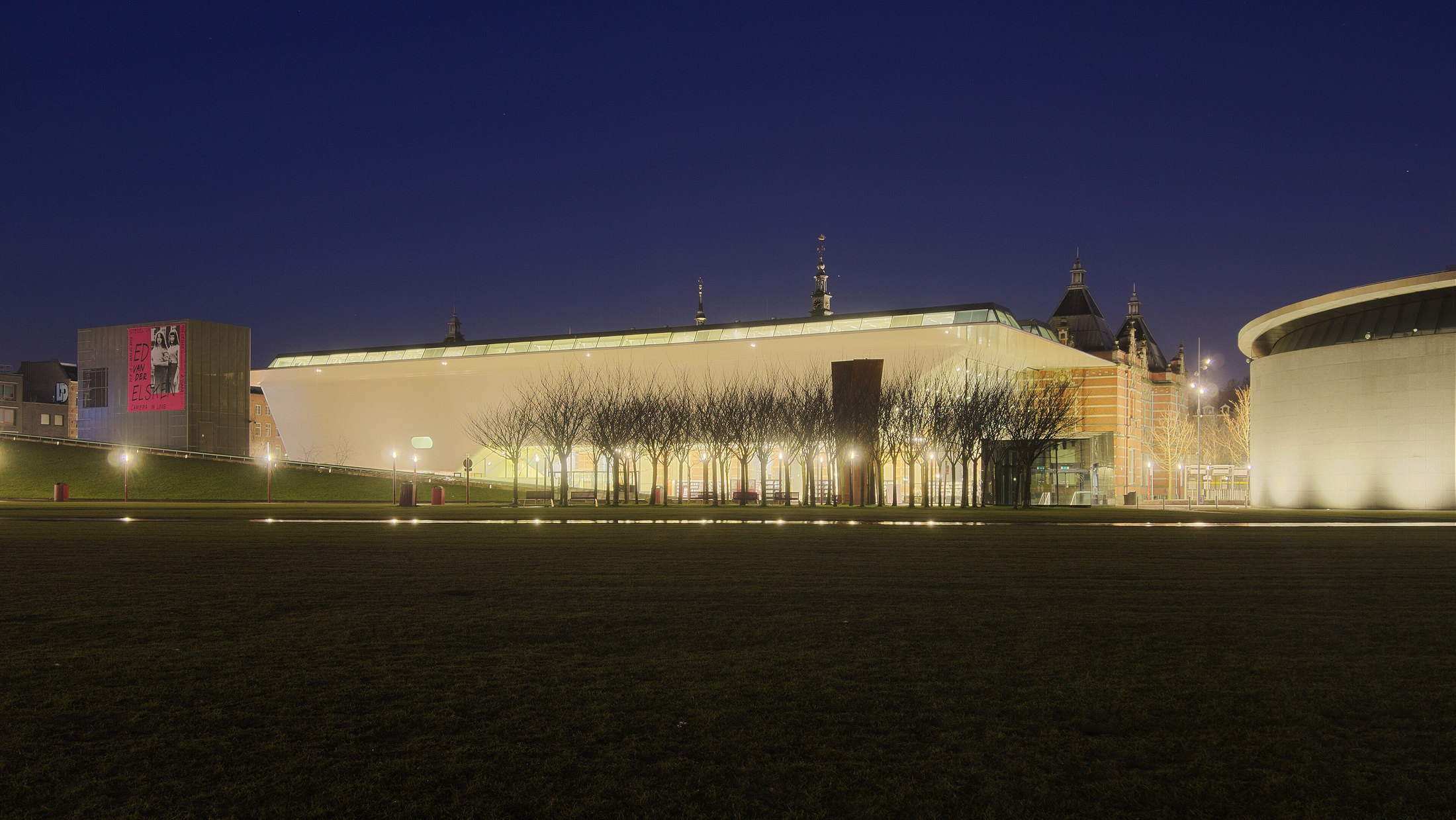 Illuminated modern wing of the Stedelijk Museum across Museumplein at night