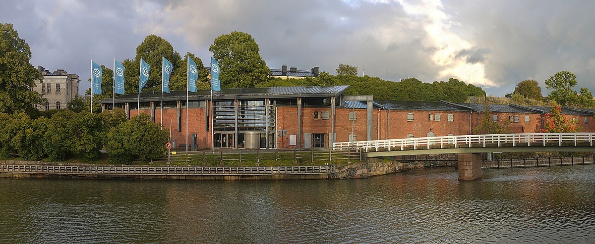 The low Suomenlinna Centre building beside the water, with fortress walls behind.