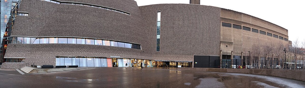 A panoramic view of Tate Modern’s brick buildings and outdoor forecourt.