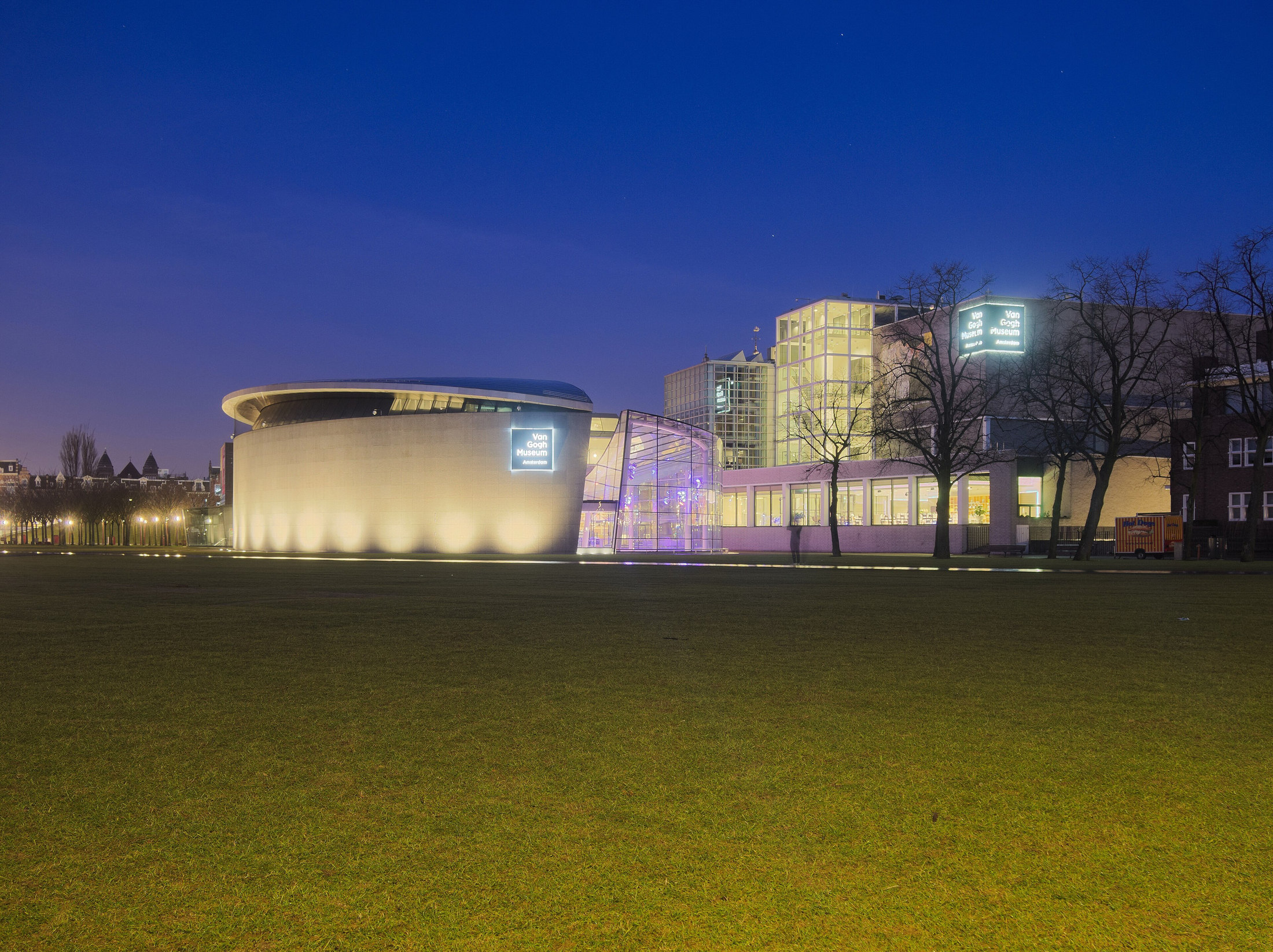 Van Gogh Museum’s curved wing and glass entrance illuminated across Museumplein