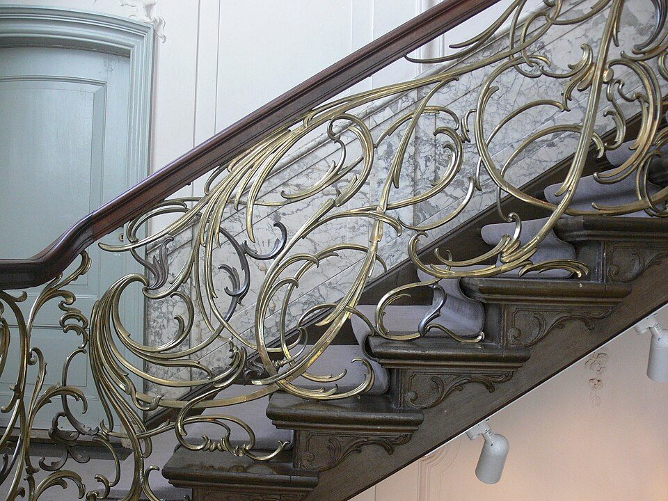 Ornate brass balustrade and marble staircase inside Museum Van Loon